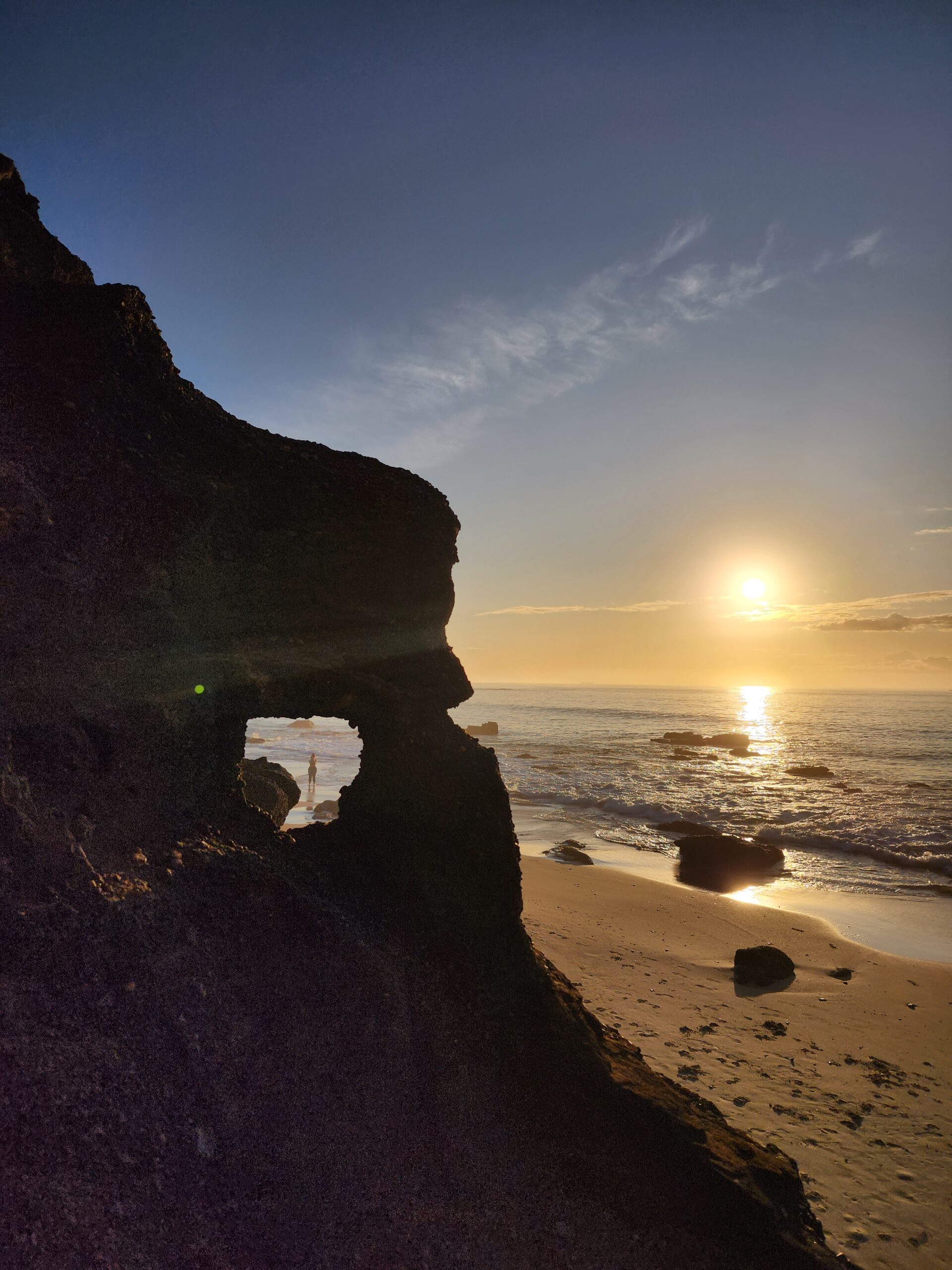 Sunrise over a beautiful beach in NSW, viewed through a natural rock formation